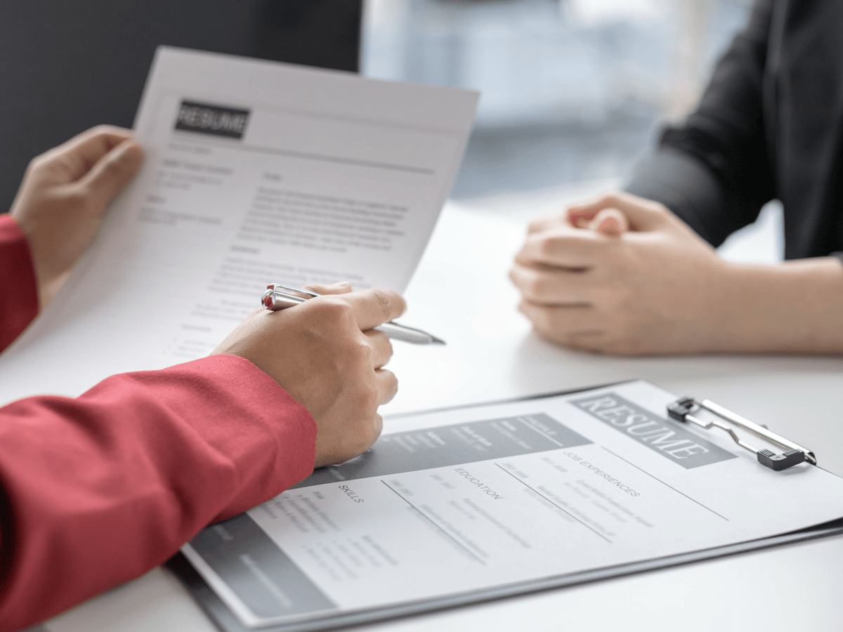 A recruiter reviewing a candidate's resume across a table during an interview